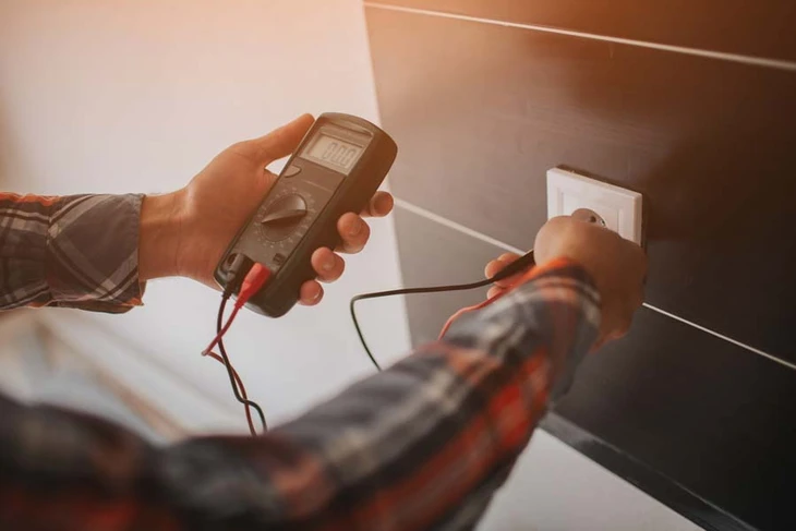 Un électricien professionnel caucasien travaillant sur l'installation d'un système de câblage électrique dans un nouveau plafond résidentiel