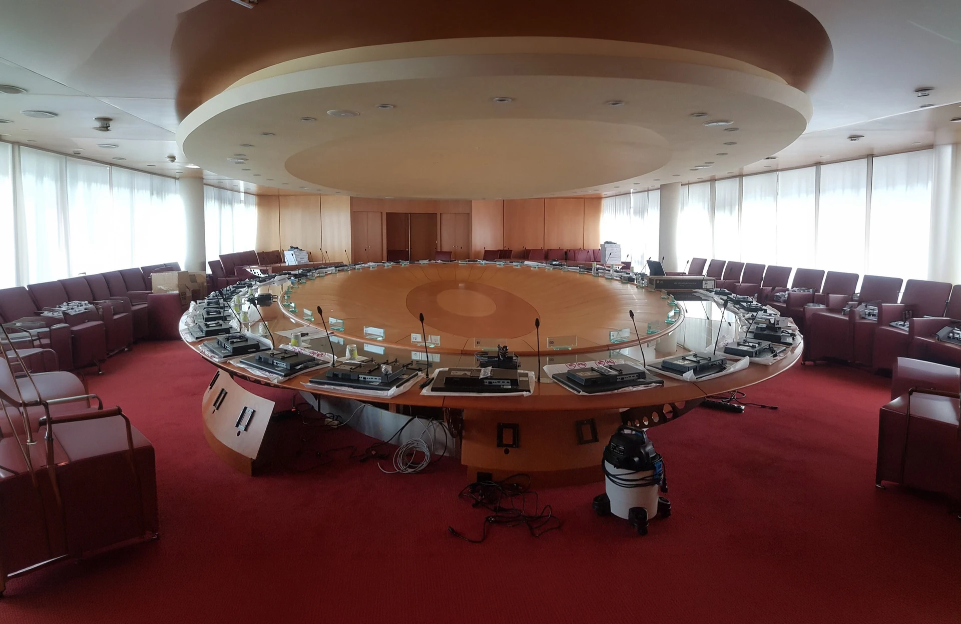 Salle de conférence moderne avec un homme en costume gris présentant devant un public d'une quinzaine de professionnels assis