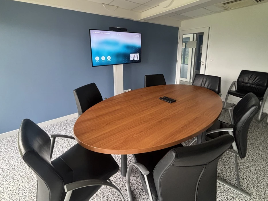 Espace de travail intérieur avec ordinateur portable argenté ouvert sur surface blanche