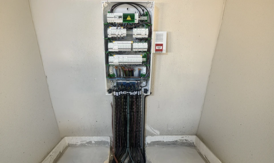 Électricien professionnel en gants de protection installant des prises électriques murales dans un intérieur résidentiel