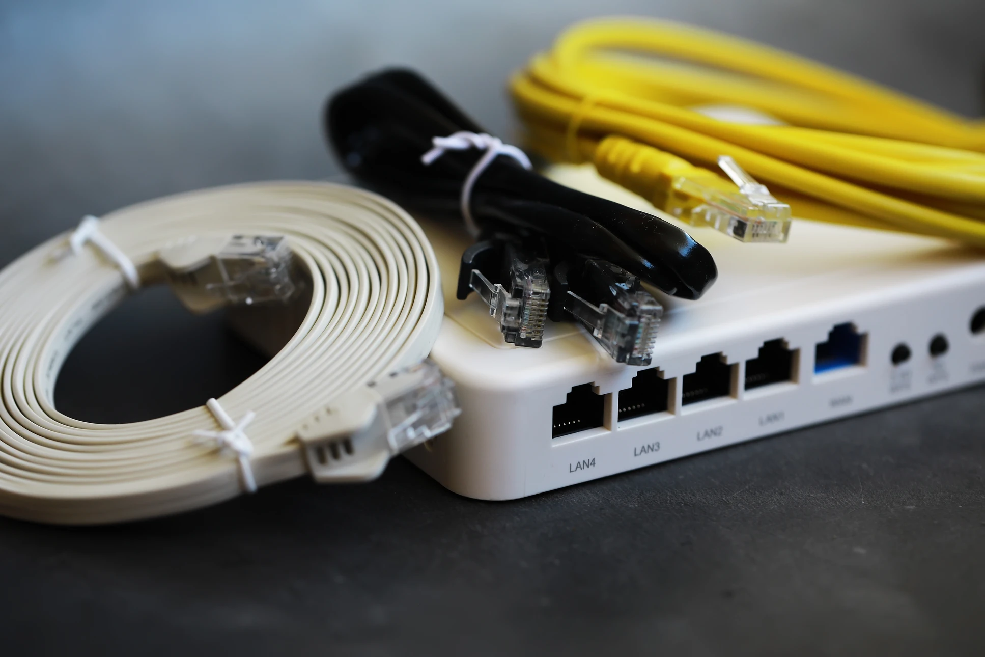 Scène d'intérieur technologique montrant un câble réseau Ethernet RJ45 connecté sur une surface métallique perforée
