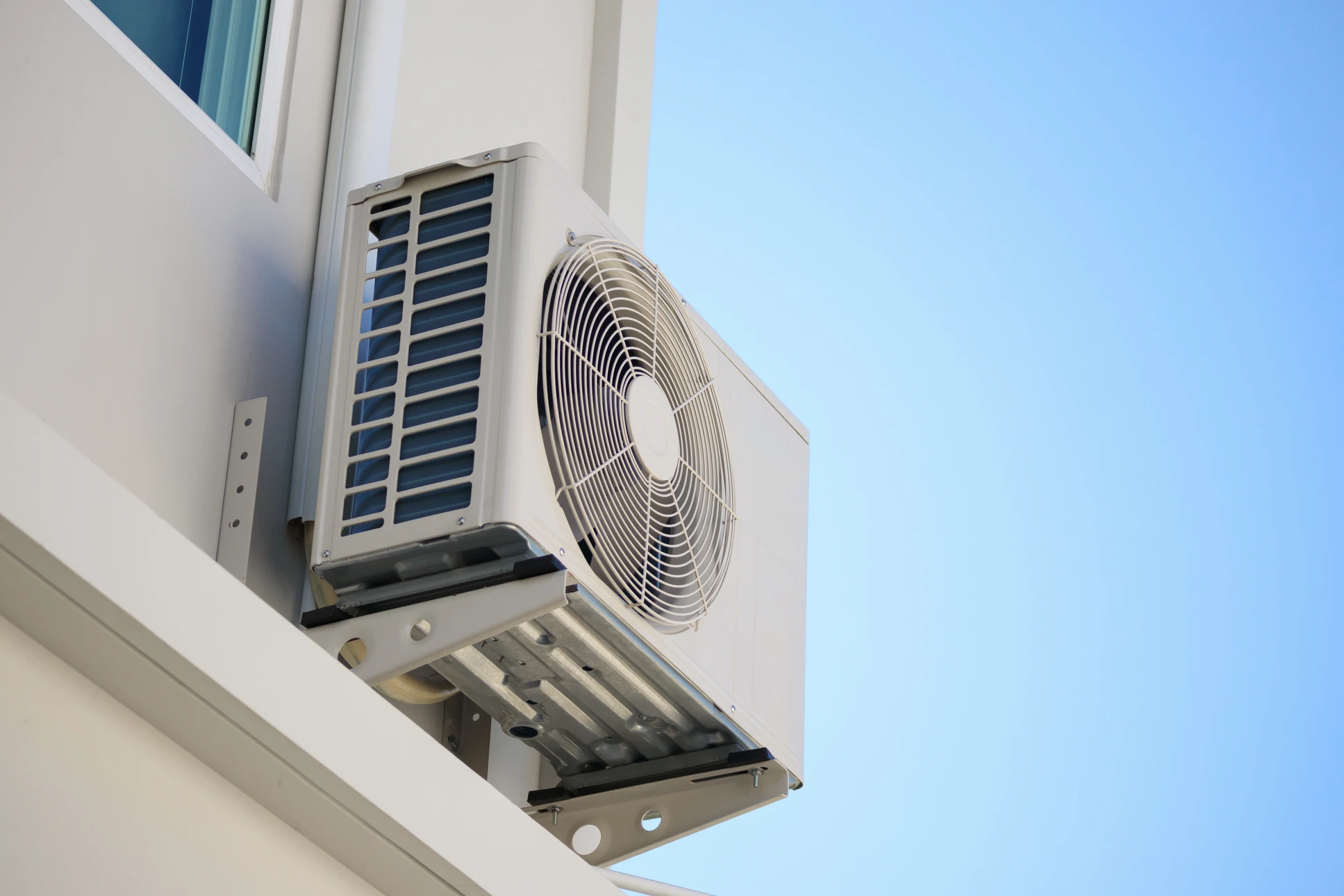 Technicien en climatisation travaillant à l'extérieur sur une pompe à chaleur ou climatiseur résidentiel